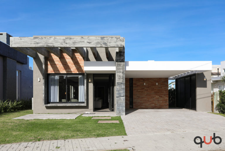 Casa com revestimento externo de tijolo e concreto aparente, no Condomínio Sea Coast